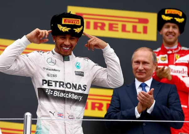 Lewis Hamilton, left, is all smiles on the podium next to Russian president Vladimir Putin, centre, and Germanys Sebastian Vettel, right. Picture: Getty Images
