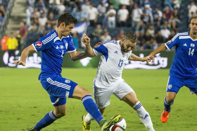 Nir Bitton challenges Cyprus midfielder Constantinos Makridis in Israel's 2-1 loss in Jerusalem. Picture: AFP/Getty Images