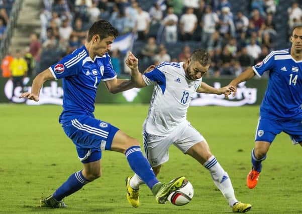 Nir Bitton challenges Cyprus midfielder Constantinos Makridis in Israel's 2-1 loss in Jerusalem. Picture: AFP/Getty Images