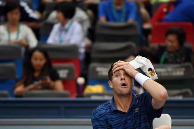 John Isner of the US wipes his head during a break in his men's singles third round match against Andy Murray. Picture: Getty