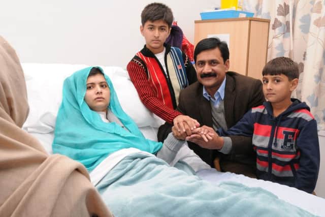 Malala with her father and brothers Kushal and Atal during treatment for her injuries at Queen Elizabeth Hospital in Birmingham. Picture: Getty Images