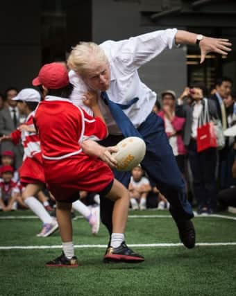 Mayor of London Boris Johnson knocks over 10 year-old Toki Sekiguchi during the rugby game in Japan. Picture: PA