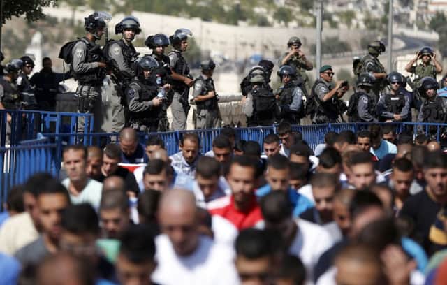 Israeli security forces stand guard as Palestinian Muslim worshippers take part in prayers yesterday in east Jerusalem. Picture: Getty