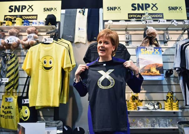 Nicola Sturgeon tries some SNP merchandise for size at the conference yesterday. Picture: Getty