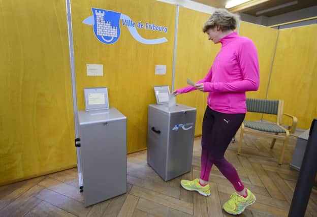 A woman casts her ballot in Fribourg, western Switzerland. Picture: Getty