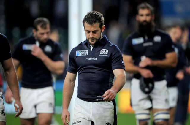 Greig Laidlaw leads a dejected Scotland off the field at Twickenham. Picture: Jane Barlow