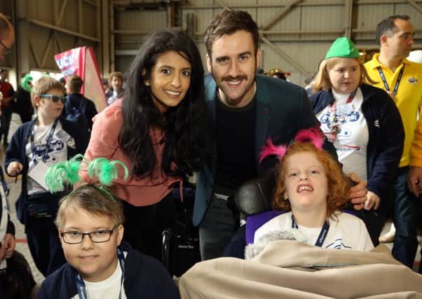 Konnie Huq and Matthew Lewis with the Dreamflight children at Heathrow Airport. Picture: PA