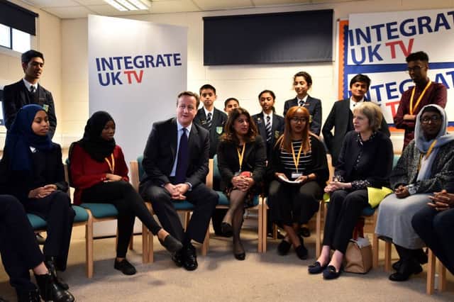 David Cameron and Home Secretary Theresa May speak to children in Luton yesterday. Picture: Getty