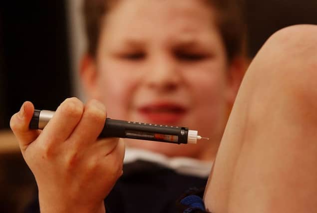 A boy with type one diabetes injects himself with insulin. The number of Scots with condition is expected to rise sharply by 2035