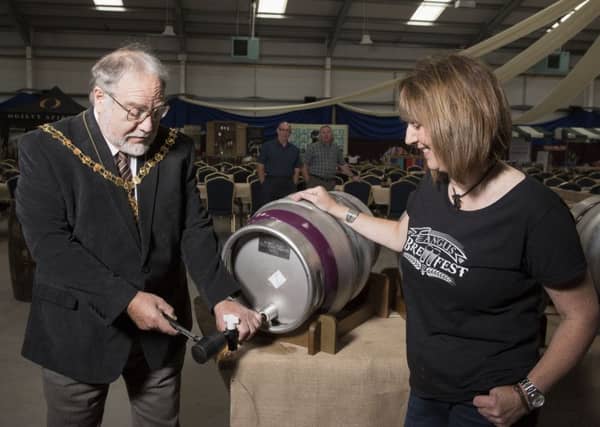 20151017- Angus Brewfest at Strathmore Hall, Forfar.
Angus Deputy Provost Alex King taps the the first barrel of Kirrie Ales beer watched by Angus Brewfest organiser Carol Robbie.
Copyright Andy Thompson Photography / ATIMAGES
No use without payment.