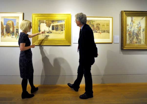 Curators Charlotte Topsfield and Kenneth McConkey taking a closer look at a painting titled The Capture of a Spy (1895). Picture: Jane Barlow