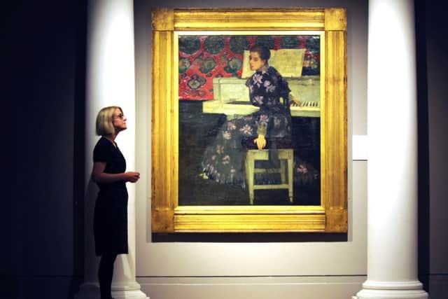 Curator Charlotte Topsfield alongside a painting titled The White Piano (1893). Picture: Jane Barlow