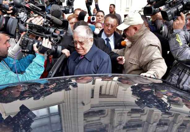Ion Iliescu, centre, leaves the court after he was interrogated by prosecutors in Bucharest yesterday. Picture: Getty