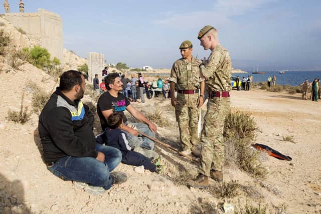 RAF personnel speak to migrants claiming asylum at Akrotiri. Picture: PA