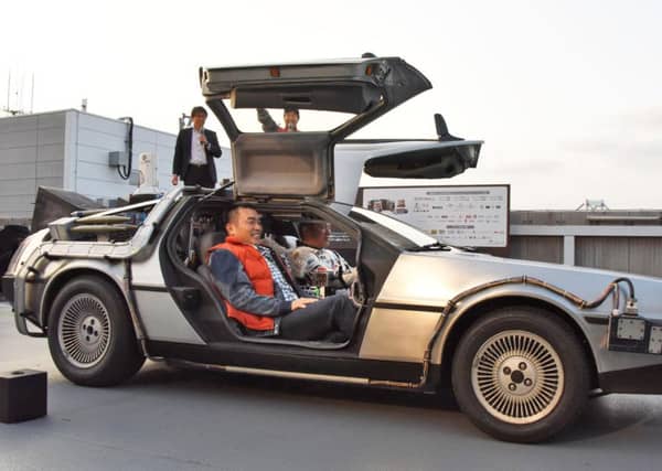 Retired Japanese professional baseball player Takeshi Yamasaki takes the wheel of a replica of the DeLorean time machine from Back to the Future. Picture: AP