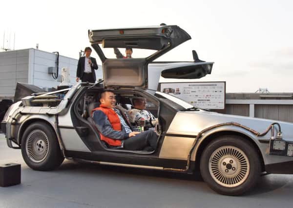Retired Japanese professional baseball player Takeshi Yamasaki takes the wheel of a replica of the DeLorean time machine from Back to the Future. Picture: AP