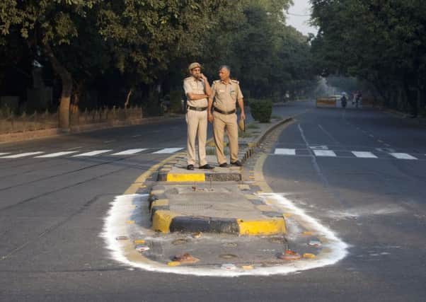 Indian policemen stand and wait for cyclists during the car-free day that covered  four miles. Picture: AP