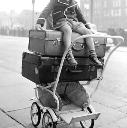 1957- 3-year-old Paul Flannigan sits on top of luggage ready to go.