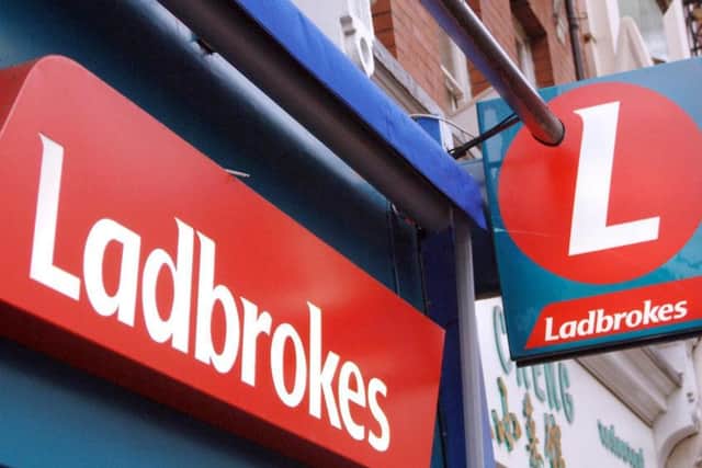 Ladbrokes said its third-quarter earnings more than halved