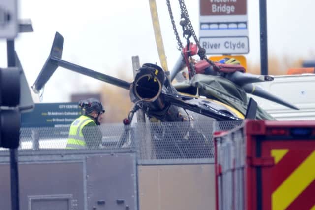 The wreckage of the police helicopter is removed from The Clutha pub.
