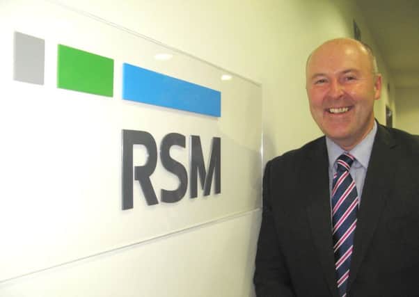 Robert Ross with the new logo for the firm, whose roots stretch back to the 1860s. Picture: Contributed