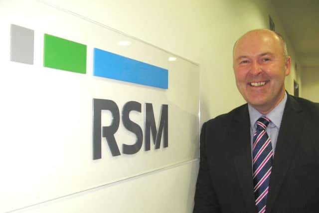 Robert Ross with the new logo for the firm, whose roots stretch back to the 1860s. Picture: Contributed