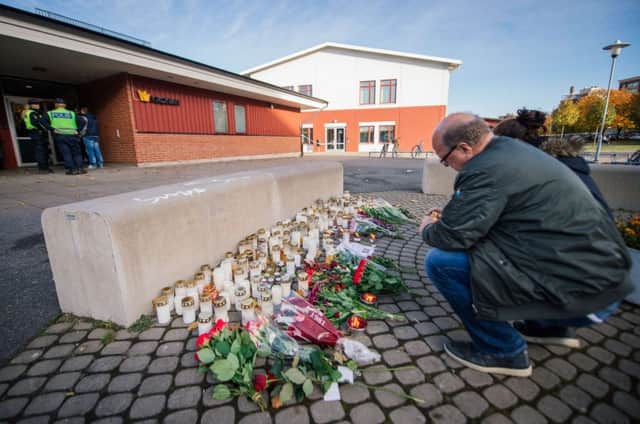 A man lights a candle in memory of the victims of the school horror. Picture: Getty