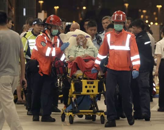 An injured passenger is escorted by rescuers after getting on shore in Hong Kong. Picture: AP
