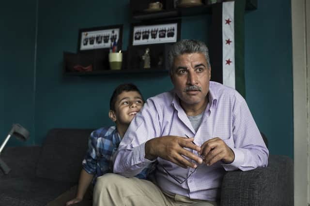Thamer Al-Johmani at home with his son Omar. Picture: Conor Ashleigh/British Red Cross/PA