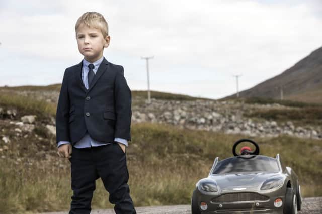 A young 007 emulates Daniel Craig's pose in Skyfall