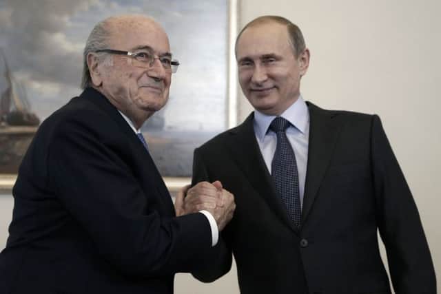Sepp Blatter shakes hands with Russian president Vladimir Putin. Picture: AP