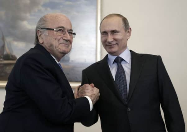 Sepp Blatter shakes hands with Russian president Vladimir Putin. Picture: AP