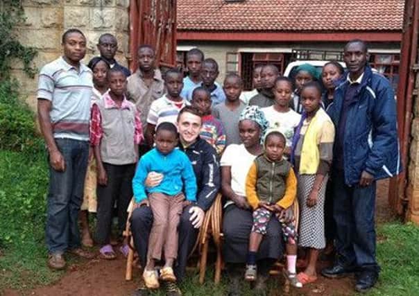 Runner Myles Edwards (front) with children at The Pavillion Village in Katarina and Kenya