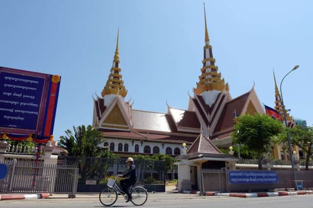 A Cambodian worker rides his bike past the National Assembly building in Phnom Penh as the country risks a political crisis. Picture: AFP/Getty