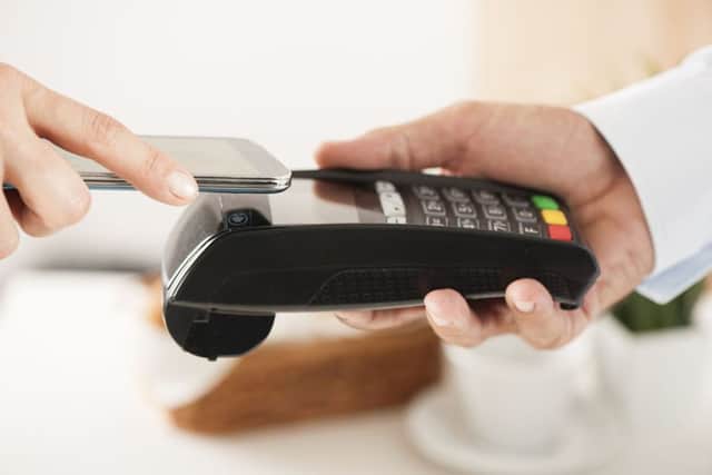 A mobile phone being used to pay for a purchase, an increasingly common sight on the high street. Picture: PA