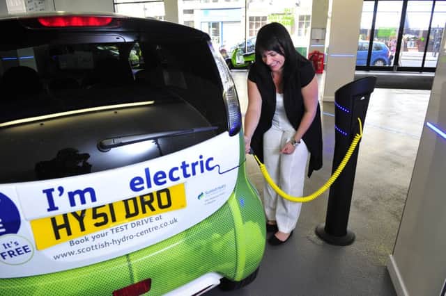 A motorist tops up an electric car in Glasgow. Picture: Robert Perry