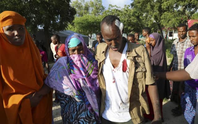 Reuters photographer Feisal Omar, who was injured in an explosion, is comforted by family members at the Medina Hospital after the attack in Mogadishu. Picture: AP