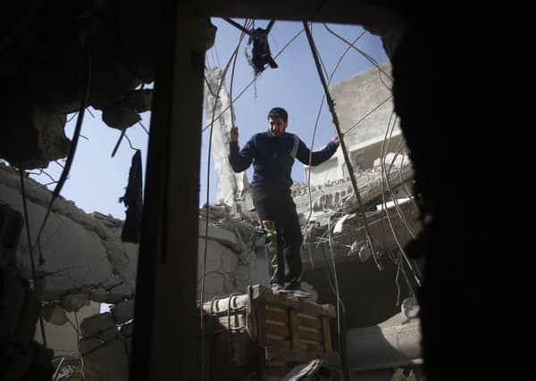 A man checks the damage after an airstrike reported to be by the government  in Syria at the weekend. Picture: AFP/Getty Images