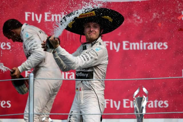 Nico Rosberg (right) celebrates his victory with teammate Lewis Hamilton on the podium after winning the Mexican Grand Prix. Picture: AFP/Getty Images