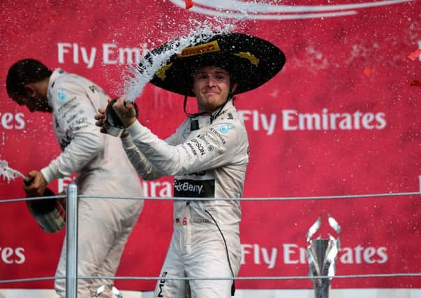 Nico Rosberg (right) celebrates his victory with teammate Lewis Hamilton on the podium after winning the Mexican Grand Prix. Picture: AFP/Getty Images