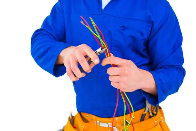 Ann electrician cutting wire with pliers. Picture: PA