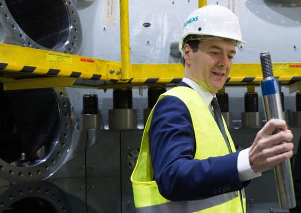 George Osborne visits a production line at a plant of German industry giant Siemens yesterday. Picture: AFP/Getty Images