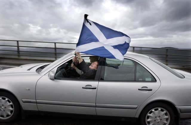 A car  drives over the Skye road bridge celebrating the end of the bridge's toll in  2004. Picture: PA