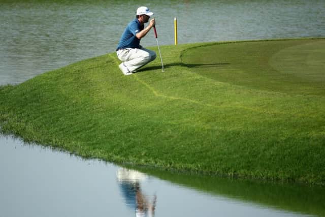 Andrew McArthur lines up his putt on the fifth green at Almouj Golf Club yesterday. Picture: Getty Images