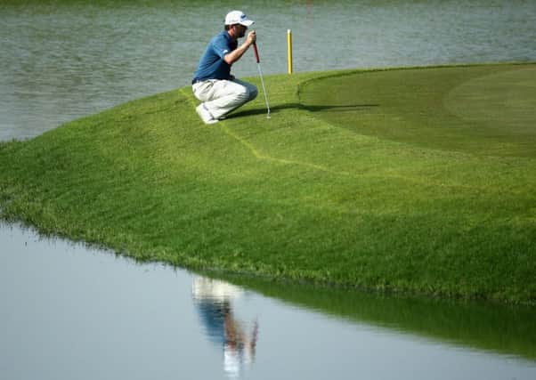 Andrew McArthur lines up his putt on the fifth green at Almouj Golf Club yesterday. Picture: Getty Images