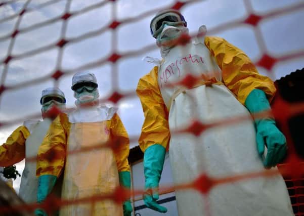 Medecins Sans Frontieres medical staff wearing protective clothing treating the body of an Ebola victim at the height of the crisis. Picture: AFP/Getty Images