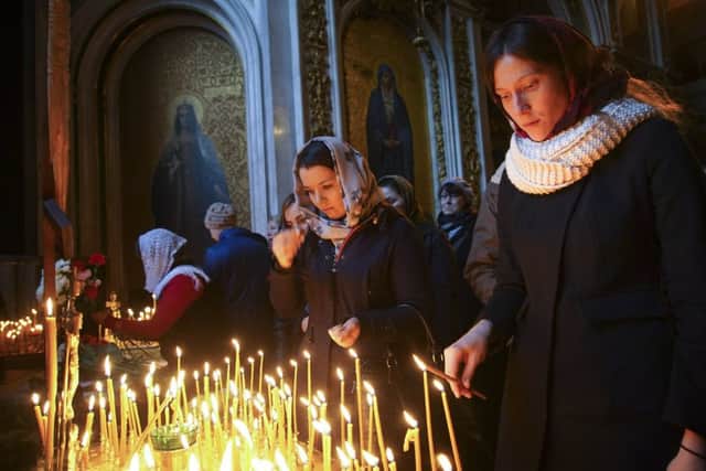 People light candles during a memorial service at the St.Isaac's Cathedral in St.Petersburg, Russia. Picture: AP
