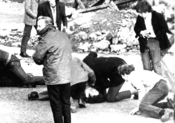 A man receives attention during the shooting in Londonderry, Northern Ireland, which became known as Bloody Sunday. Picture: PA