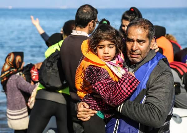 A man comforts a girl after their arrival into Europe by dinghy from the Turkish coast to the north-eastern Greek island of Lesbos.. Picture: AP