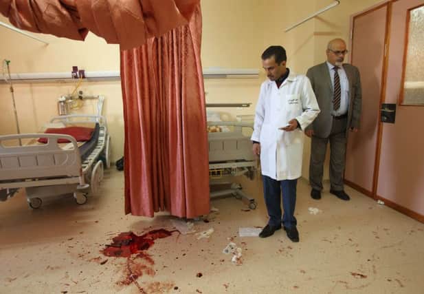 A doctor examines the bloodstained aftermath of the attack in Hebron. Picture: Getty